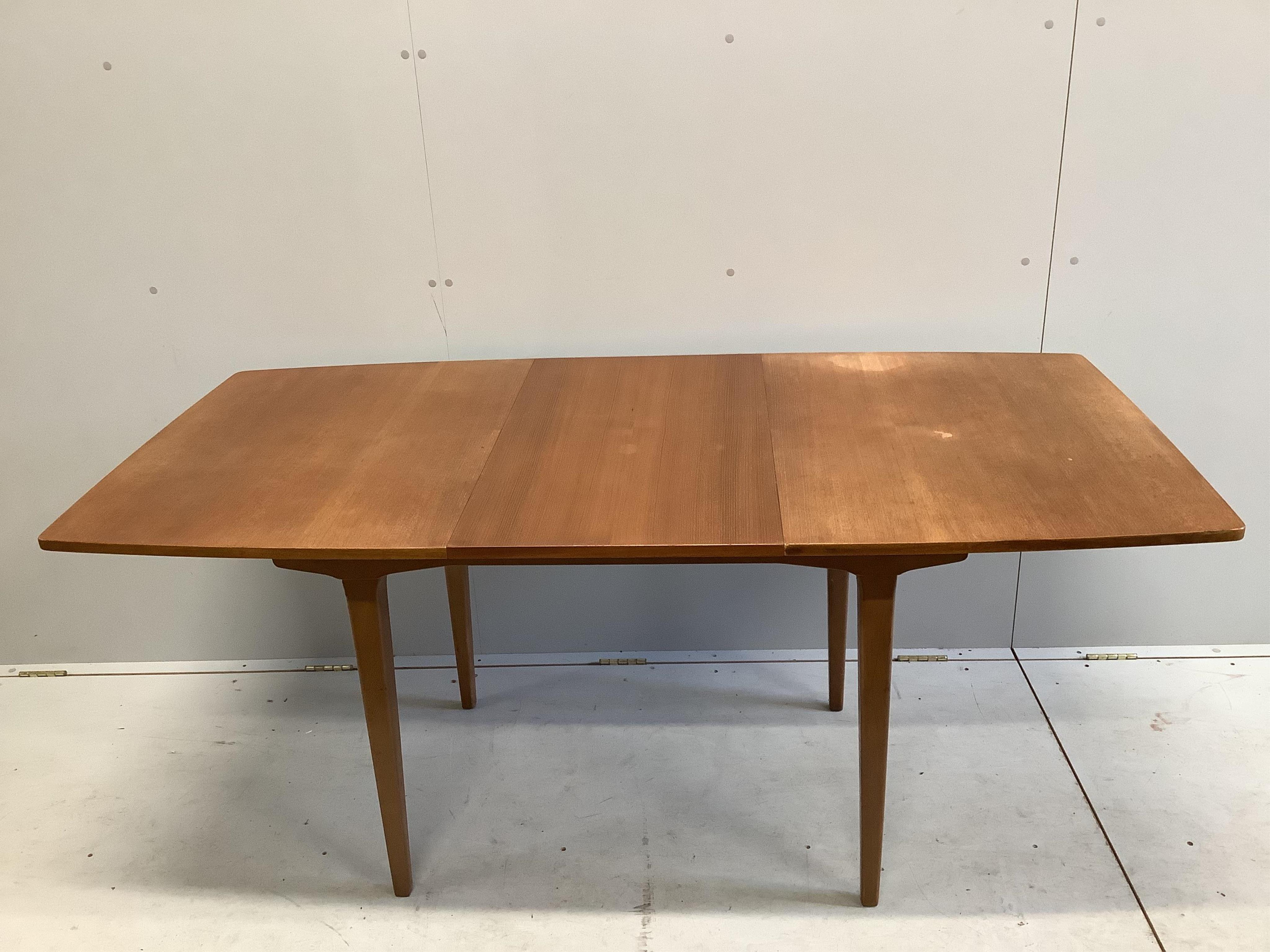 A mid century teak extending dining table, 174cm extended, one spare leaf, depth 83cm, height 74cm. Condition - fair